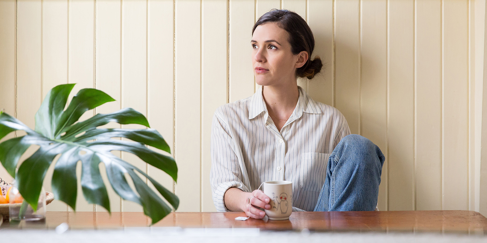 Adriene at table staring off in the distance